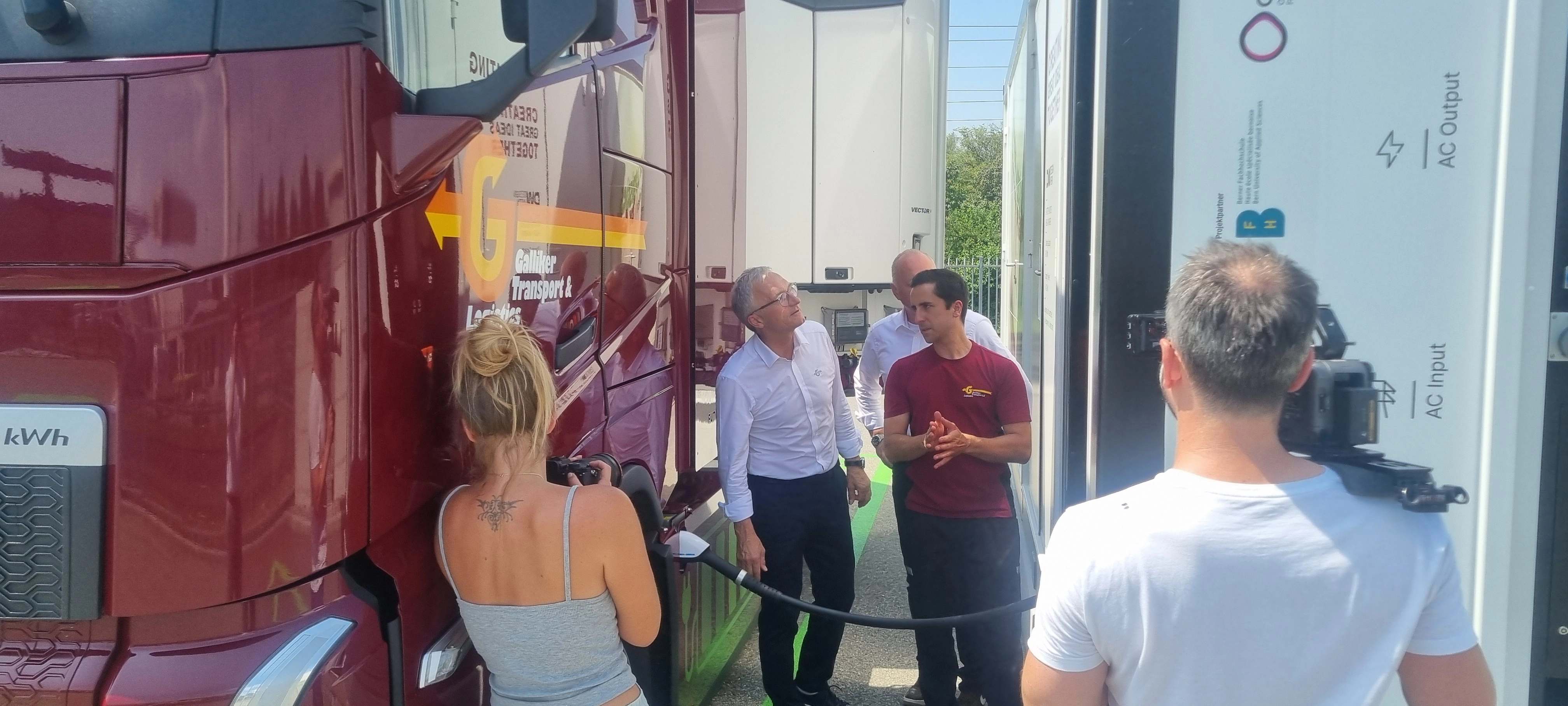 Gespräch vor dem Elektro-Lastwagen an der Ladestation