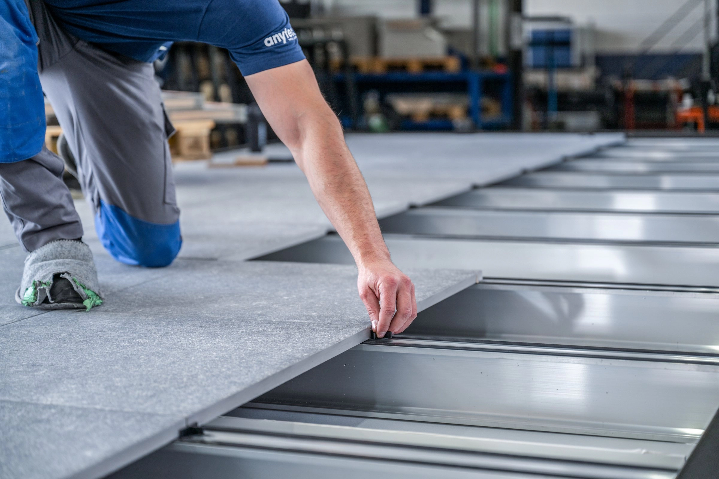 Monteur verschraubt Metallbauteile in der Werkstatt